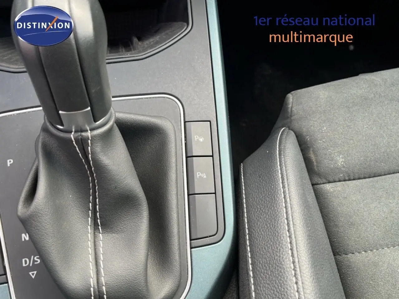 Gros plan sur la console centrale et levier de vitesse cuir noir de la SEAT Arona 2025, intérieur tissu gris et cuir.