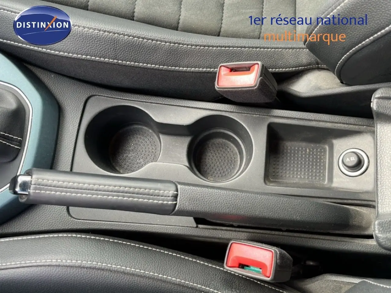 Vue intérieure centrée sur la console centrale avec frein à main, porte-gobelets et sellerie noire du SEAT Arona 2025.