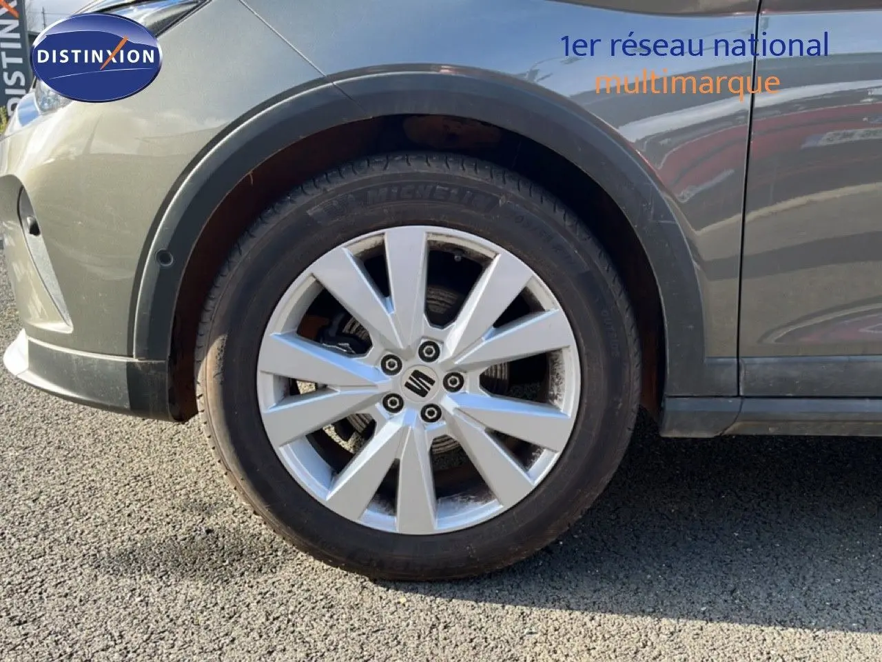 Gros plan sur la roue avant gauche d’un SEAT Arona gris magnétique, mettant en valeur la jante alliage 17 pouces.