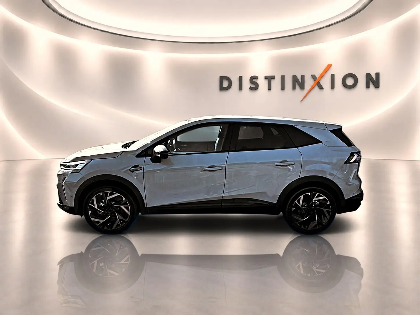Profil droit de la Renault Symbioz gris rafale avec jantes noires, dans un studio lumineux marqué Distinxion.