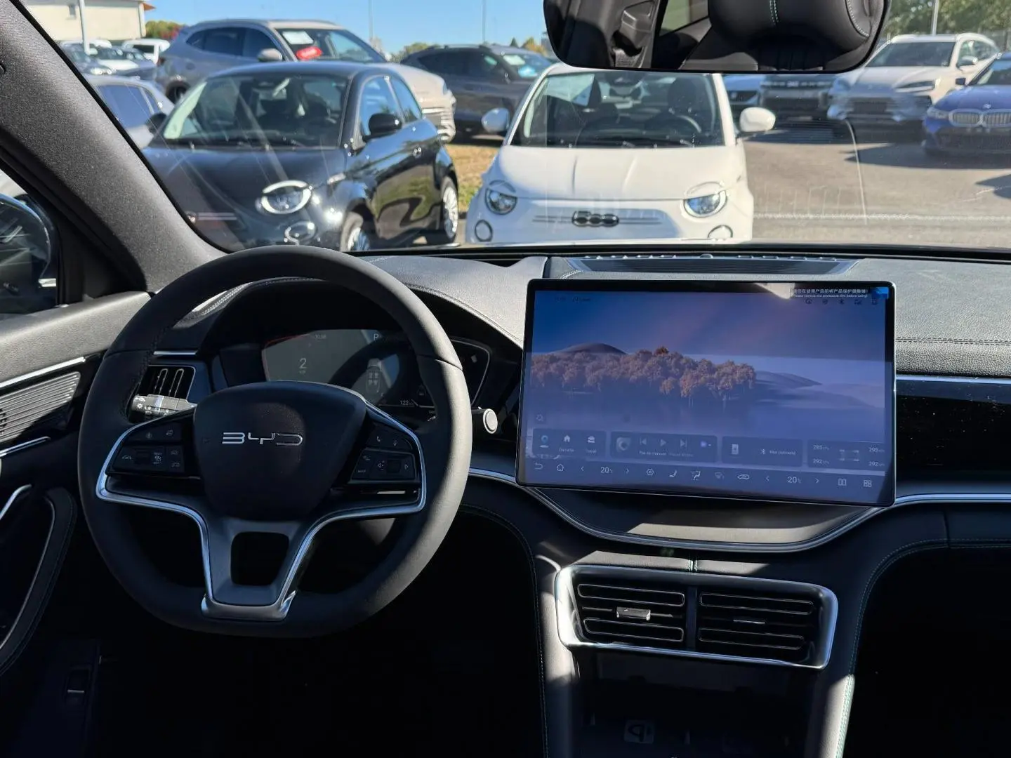 Vue intérieure frontale du tableau de bord du BYD SEAL U 2026 avec écran tactile large et volant multifonction noir.