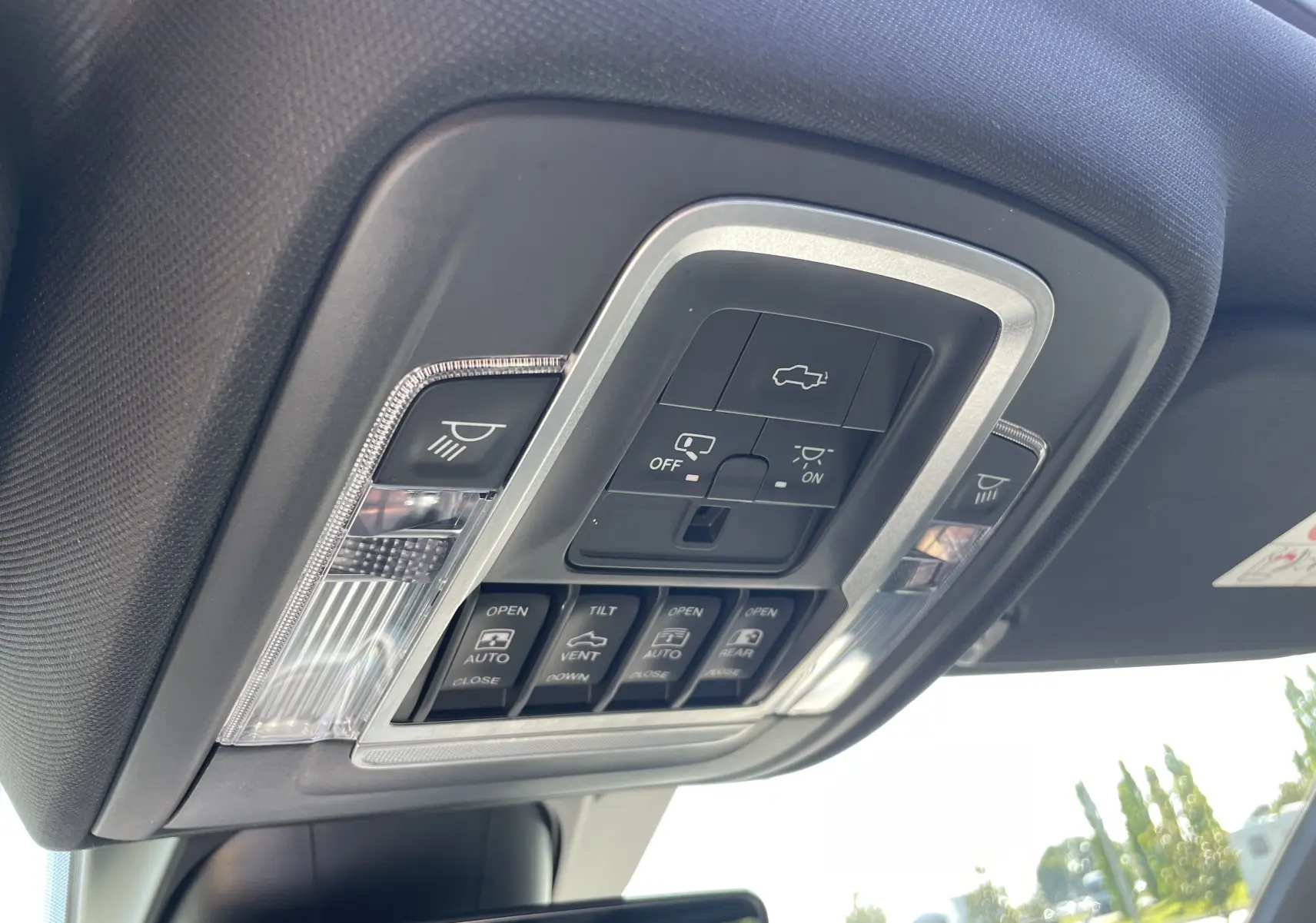 Gros plan sur la console de plafonnier du Dodge RAM 1500 2020, avec commandes d'éclairage et toit ouvrant visibles.