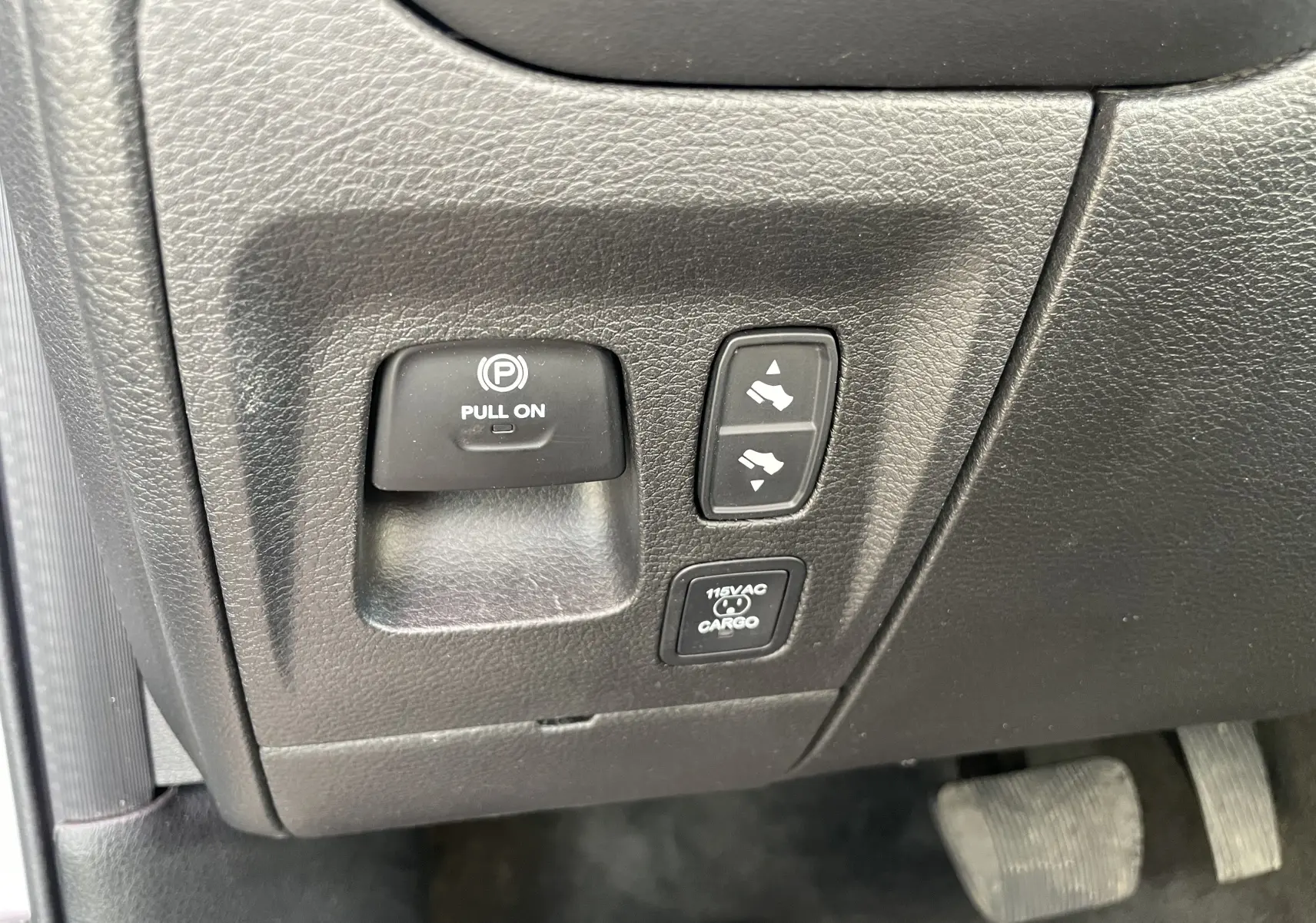Gros plan sur les commandes noires du frein à main électrique et réglages des pédales du Dodge RAM 1500 blanc nacré 2020.