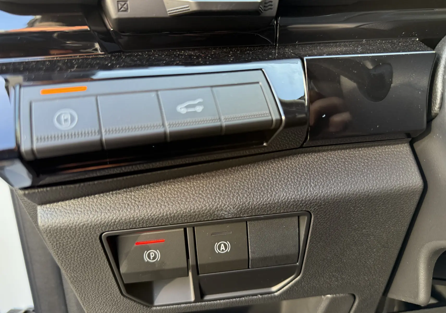 Gros plan sur les commandes de stationnement et assistance au démarrage du Renault Austral 2025, intérieur noir.