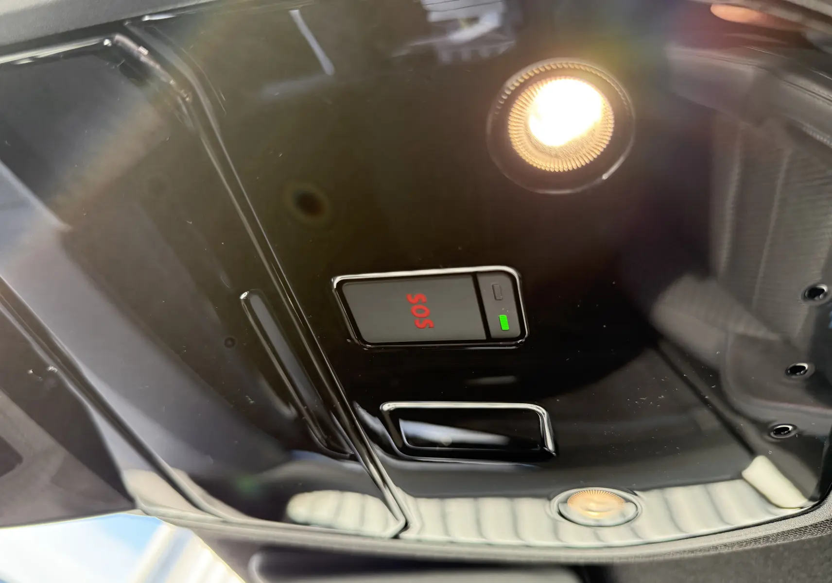 Détail du plafonnier noir brillant avec bouton SOS rouge et éclairage intérieur du Renault Austral 2025 blanc nacré toit noir.