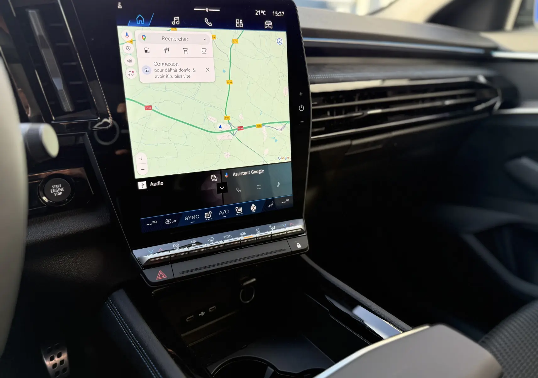 Vue intérieure du tableau de bord du Renault Austral 2025, écran tactile central avec navigation et commandes climatiques visibles.