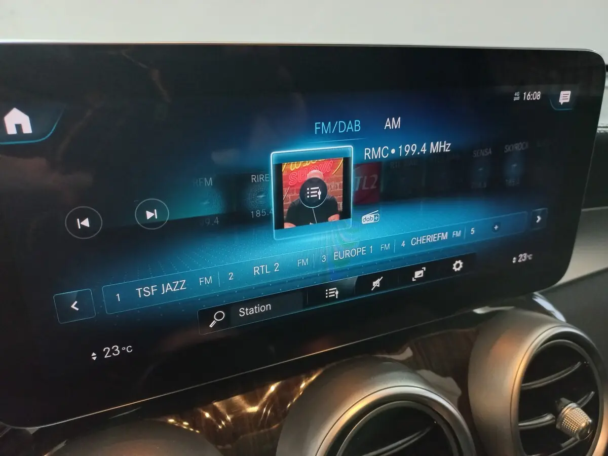 Écran tactile central du Mercedes GLC 300 E Business Line 2021 affichant les stations radio, avec aérateurs ronds chromés en dessous.