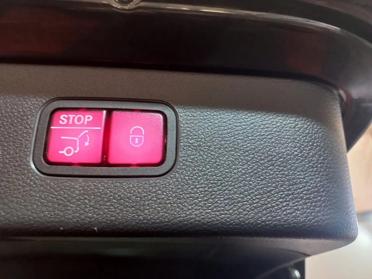 Boutons rouges stop et verrouillage du coffre sur le panneau intérieur d'un Mercedes GLC noir hybride rechargeable 2021.