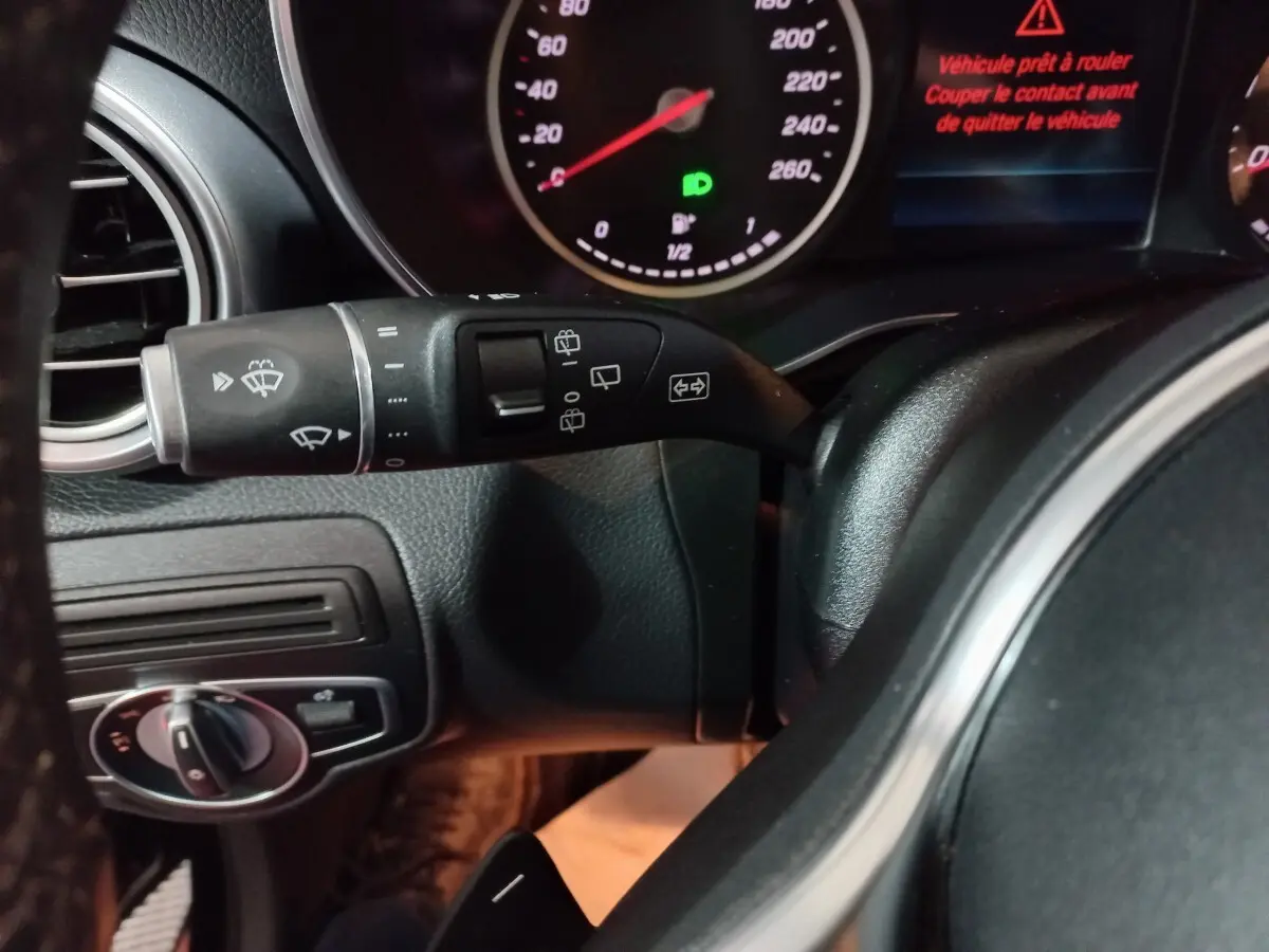 Gros plan sur le commodo gauche et tableau de bord du Mercedes GLC 300 E Business Line noir, affichage digital rouge visible.