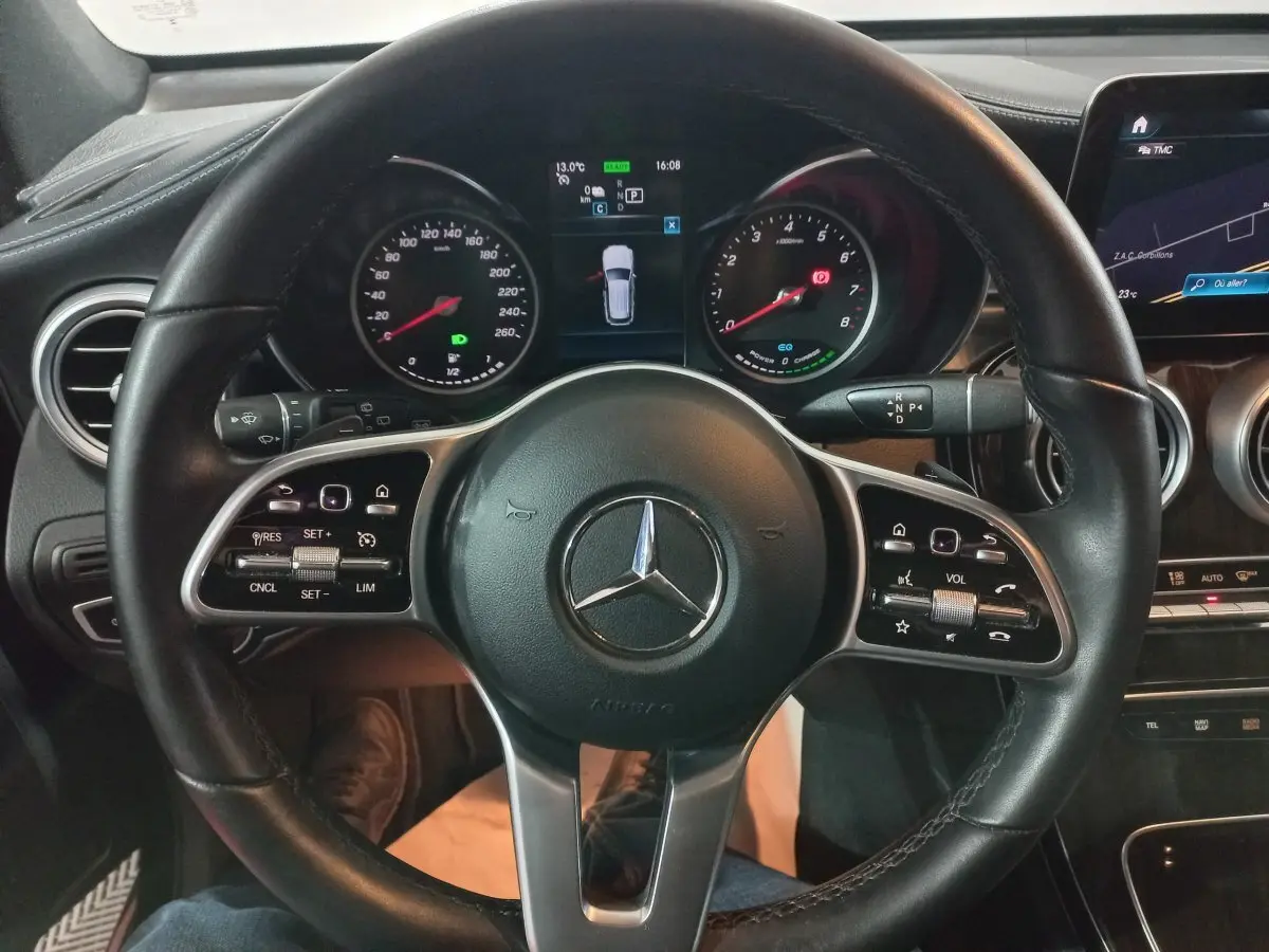 Vue rapprochée du volant cuir noir et du tableau de bord digital du Mercedes GLC 300 E Business Line 2021.