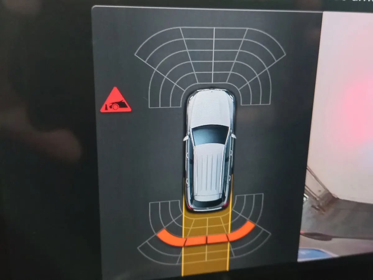 Vue de dessus de la Mercedes GLC noire affichée sur écran, avec alertes de capteurs de stationnement arrière activées.