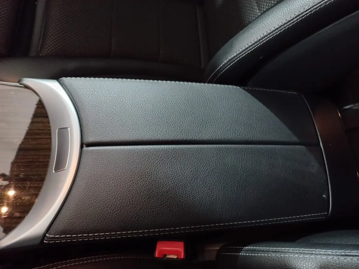 Gros plan sur l'accoudoir central en cuir noir avec surpiqûres blanches à l'intérieur d'un Mercedes GLC 300 E Business Line 2021.