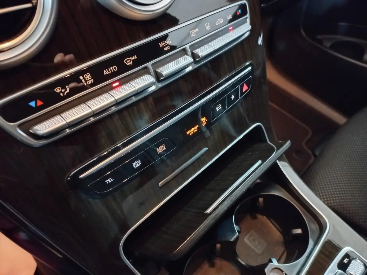 Gros plan sur la console centrale en bois foncé du Mercedes GLC 300 E Business Line 2021, avec commandes climatisation et rangements.