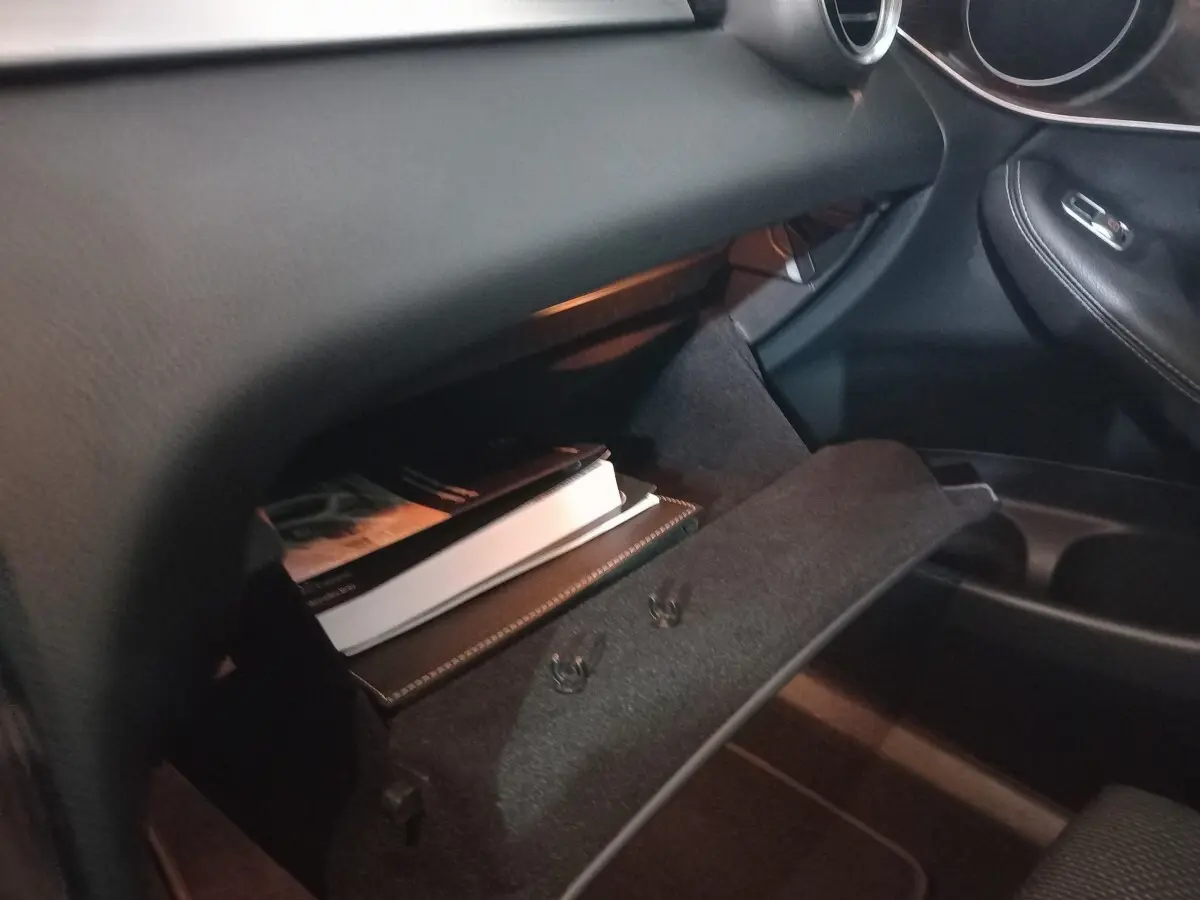 Gant de boîte à gants ouvert côté passager dans l'habitacle noir du Mercedes GLC 300 E Business Line 2021.