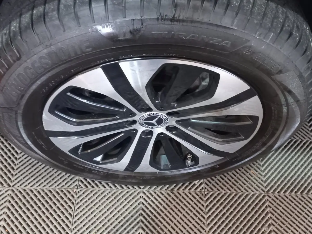 Gros plan sur la jante alliage bicolore noire et argentée d'un Mercedes GLC 300 E Business Line noir de 2021.