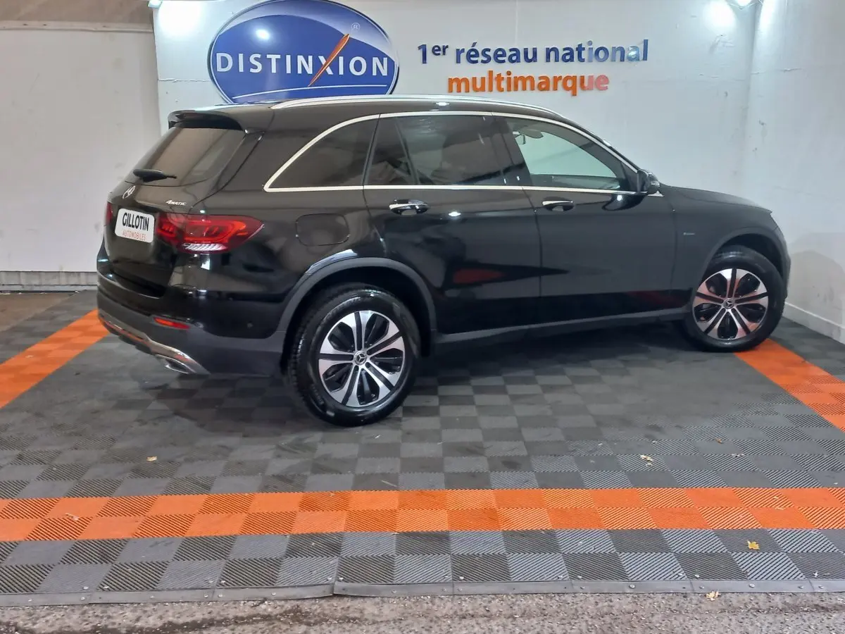 Vue de profil côté gauche d'un Mercedes GLC 300 E Business Line 4MATIC noir stationné en intérieur.
