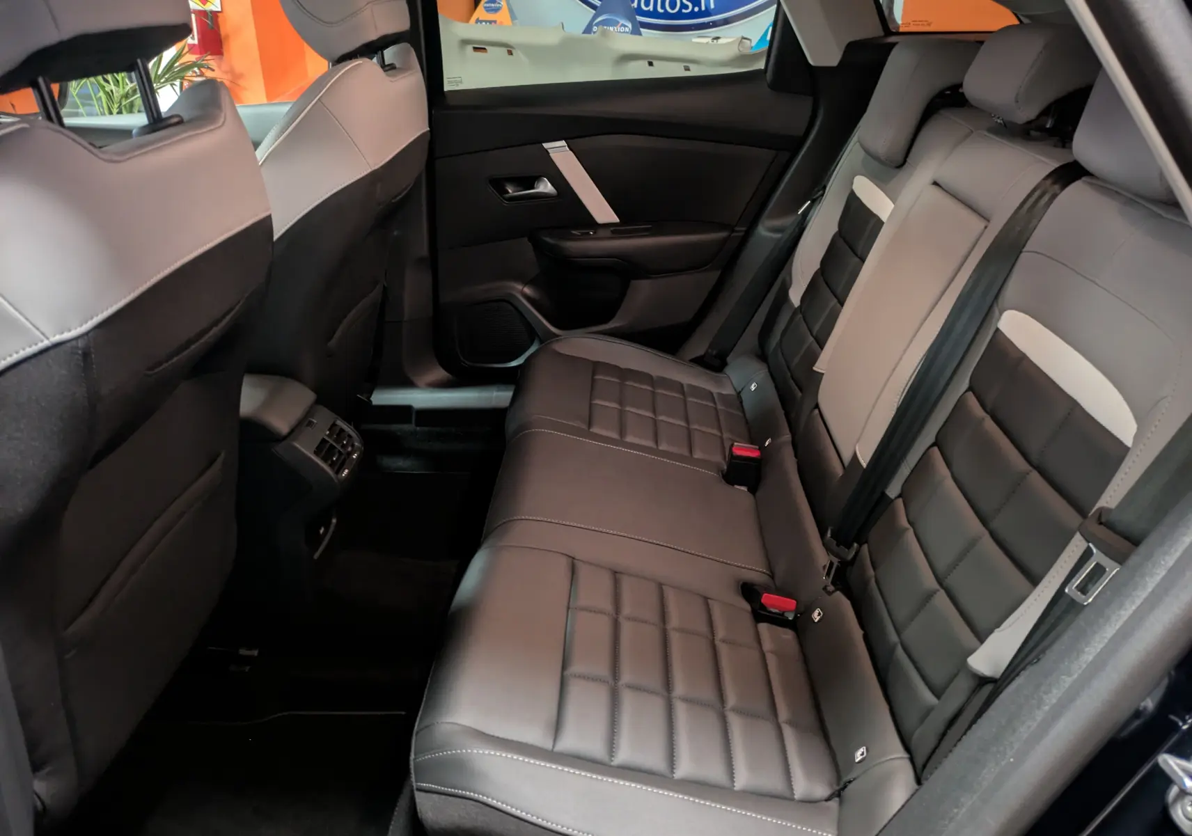 Vue intérieure arrière droite des sièges en cuir noir et gris de la Citroën C4 Hybride 145 e-DCS6 Max 2025.