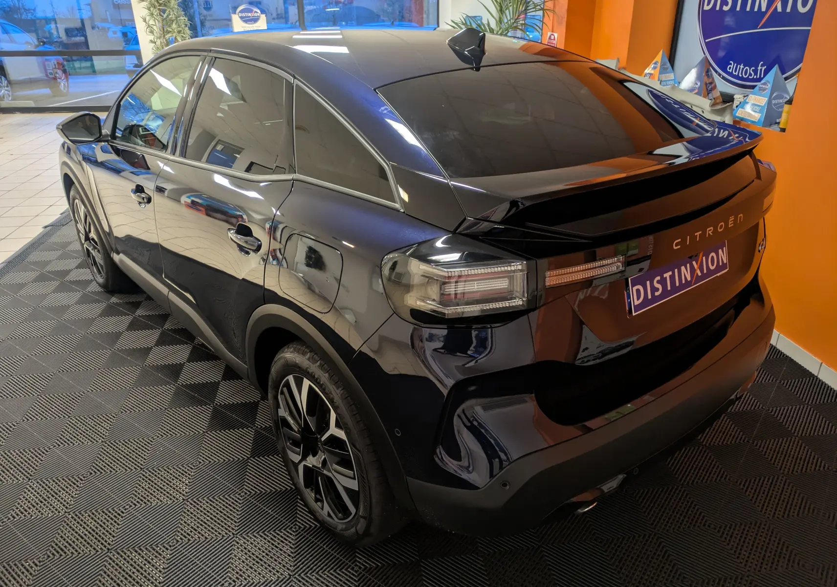 Vue 3/4 arrière droite d'une Citroën C4 hybride bleu nuit avec jantes alliage 18 pouces et vitres teintées.