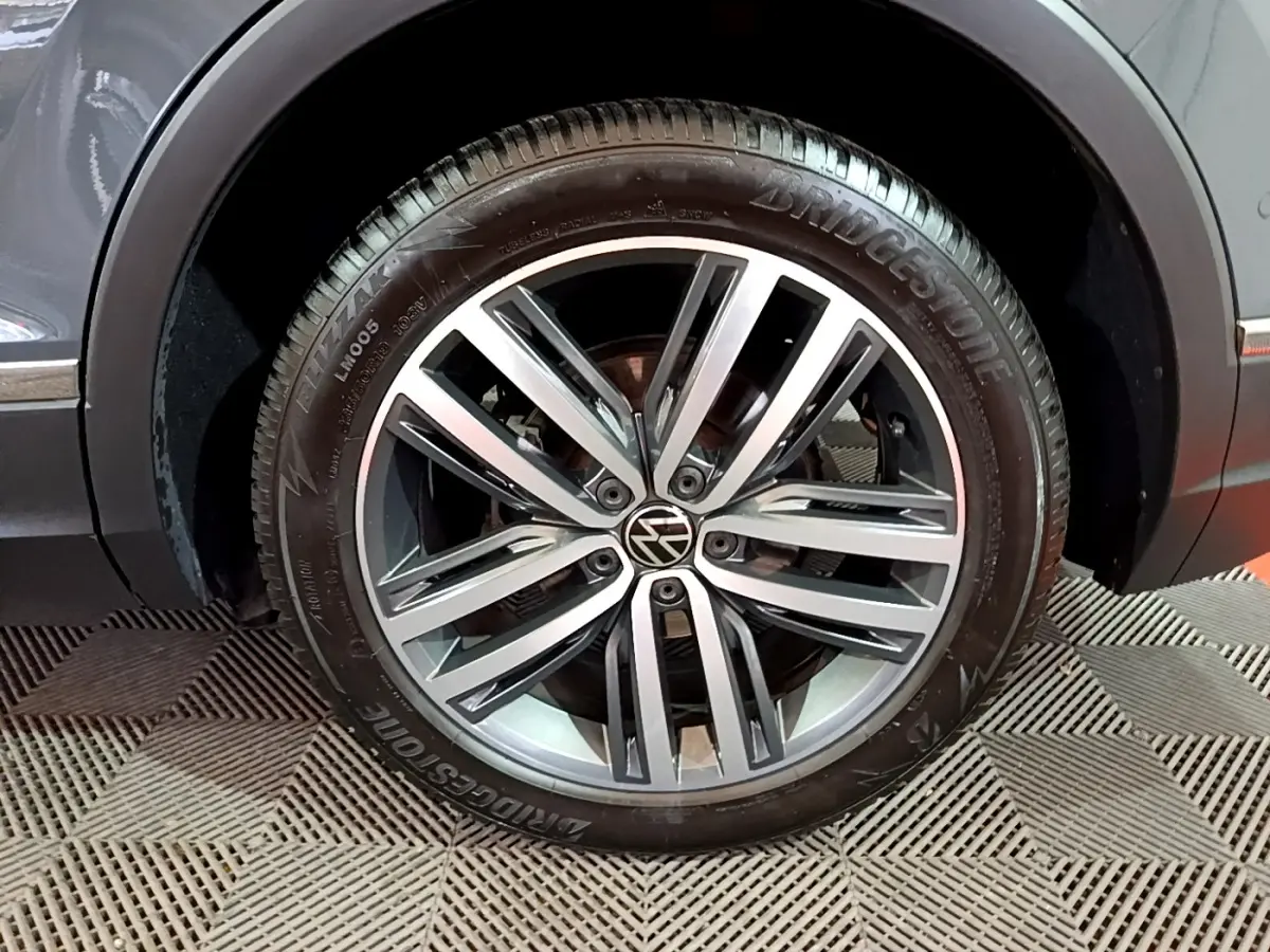 Gros plan sur la roue avant droite gris clair du Volkswagen Tiguan 2.0 TDI 150 DSG7 Elegance avec jante alliage et pneu Bridgestone.
