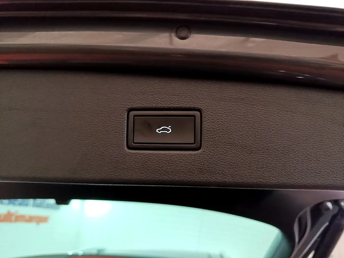 Bouton d'ouverture électrique du coffre sur la partie intérieure du hayon du Volkswagen Tiguan gris clair 2022.