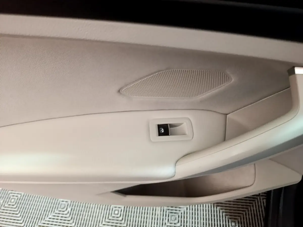 Détail de la porte intérieure beige clair du Volkswagen Tiguan 2022, avec commande de verrouillage visible.