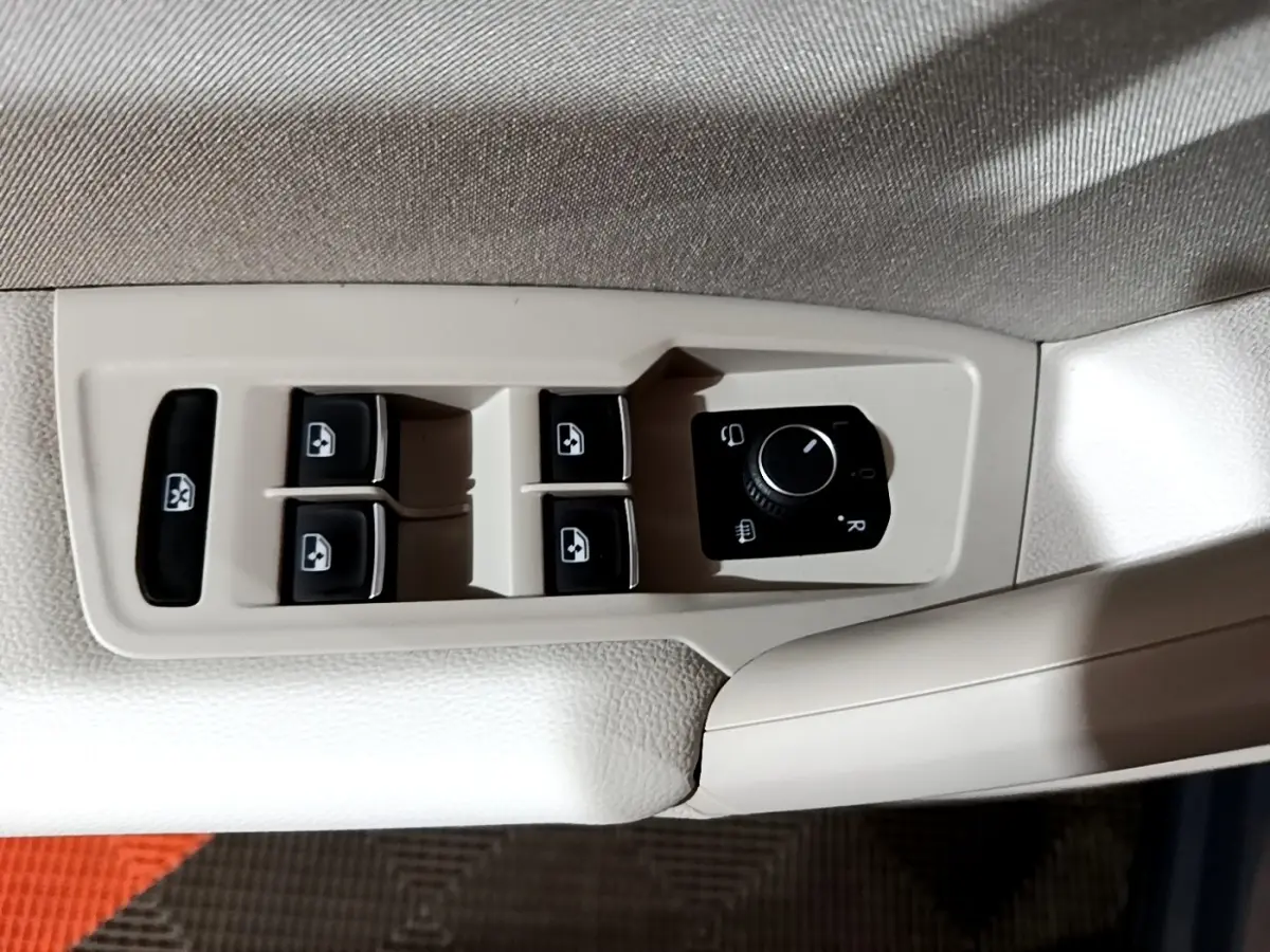 Commande des vitres électriques et réglage des rétroviseurs sur la porte côté conducteur du Volkswagen Tiguan gris clair 2022.