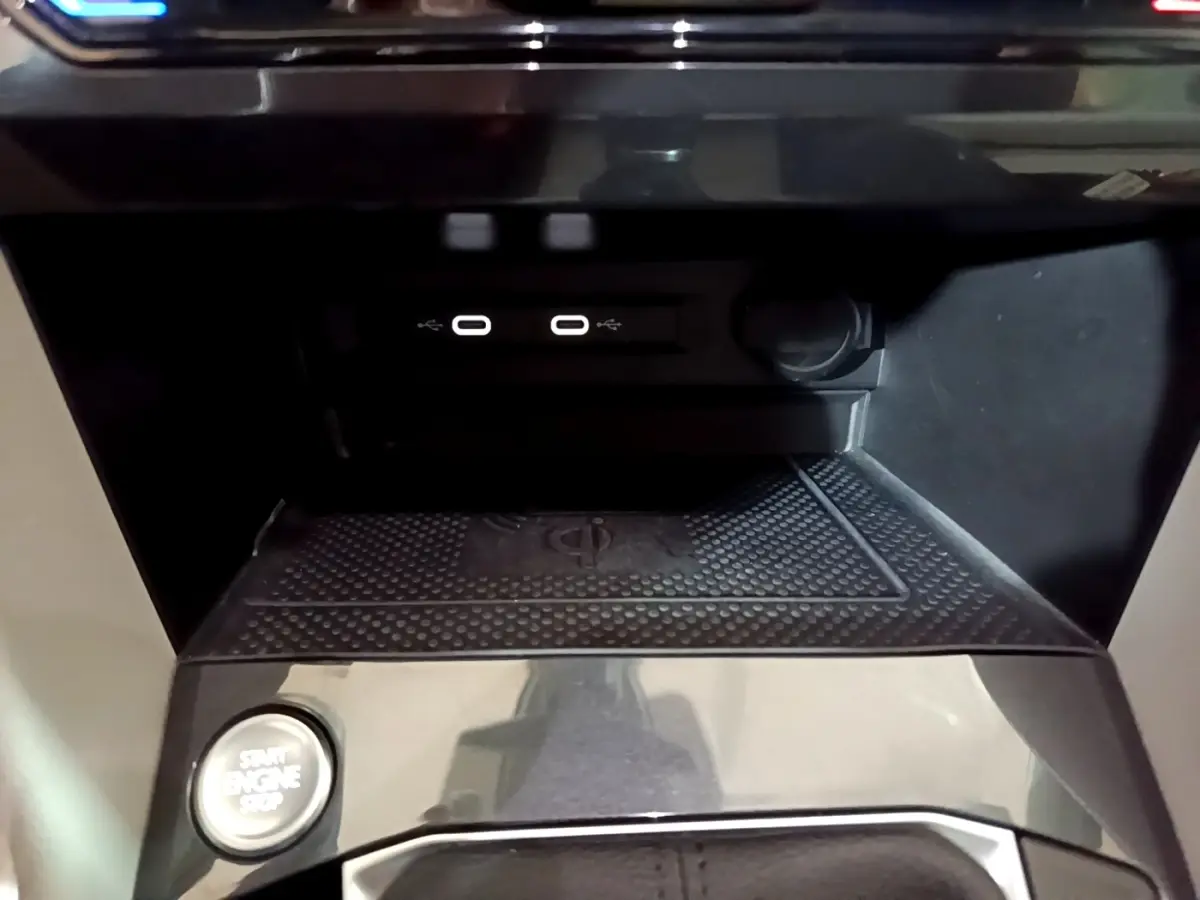 Gros plan sur la console centrale noire du Volkswagen Tiguan 2022, avec ports USB-C et bouton démarrage.