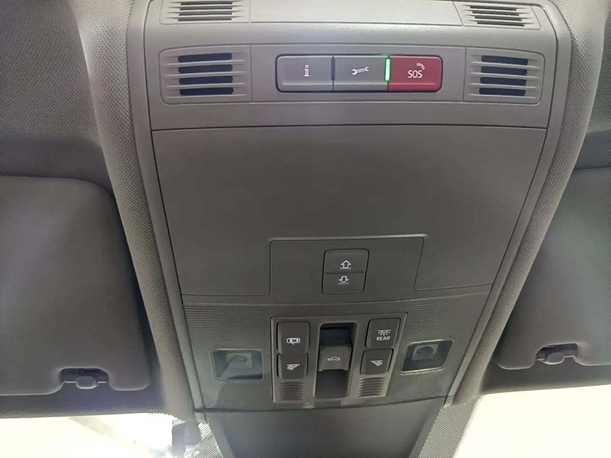 Vue en contre-plongée du panneau de commandes du toit ouvrant et des éclairages intérieurs du Volkswagen Tiguan gris clair 2022.