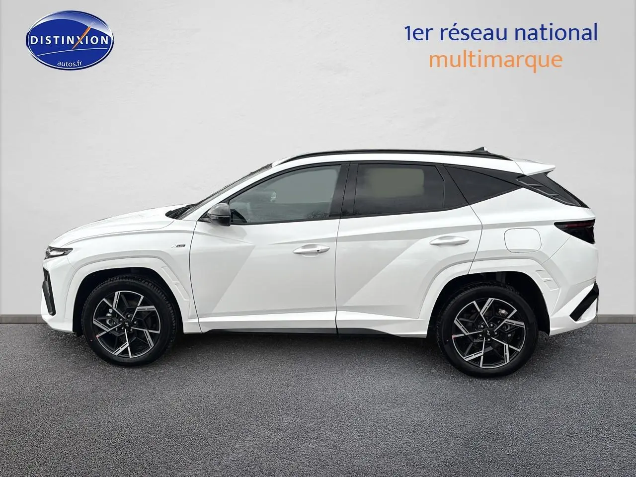 Vue de profil côté gauche du Hyundai Tucson blanc sérénité avec jantes alliage 19 pouces et toit noir contrasté.