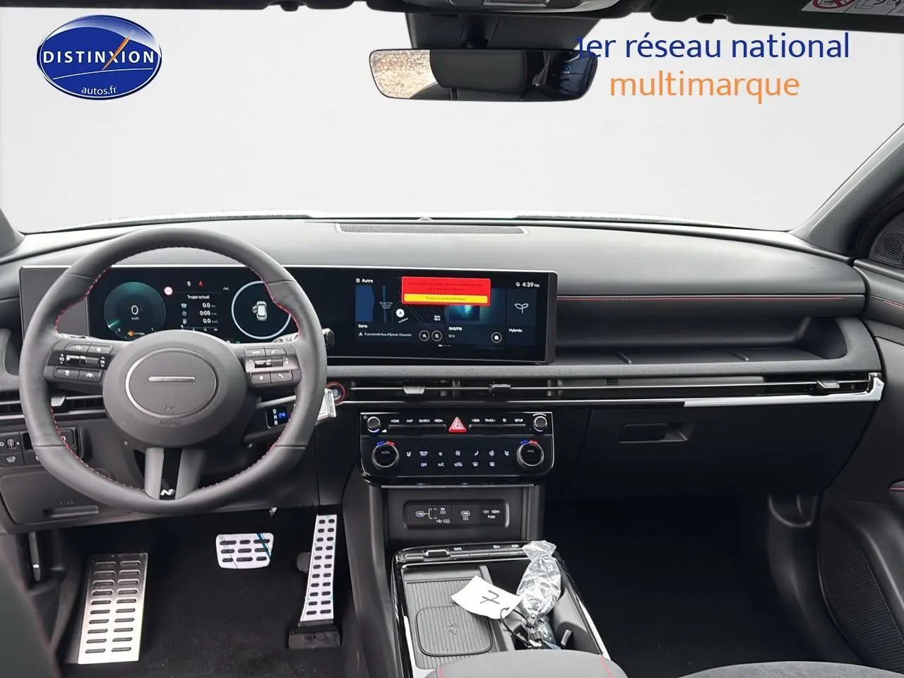 Vue intérieure avant du Hyundai Tucson 2026 blanc sérénité, tableau de bord numérique et volant cuir multifonction N Line.