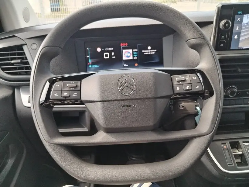 Vue rapprochée du volant noir de la Citroën Jumpy Cabine Approfondie 2025 avec tableau de bord numérique en arrière-plan.