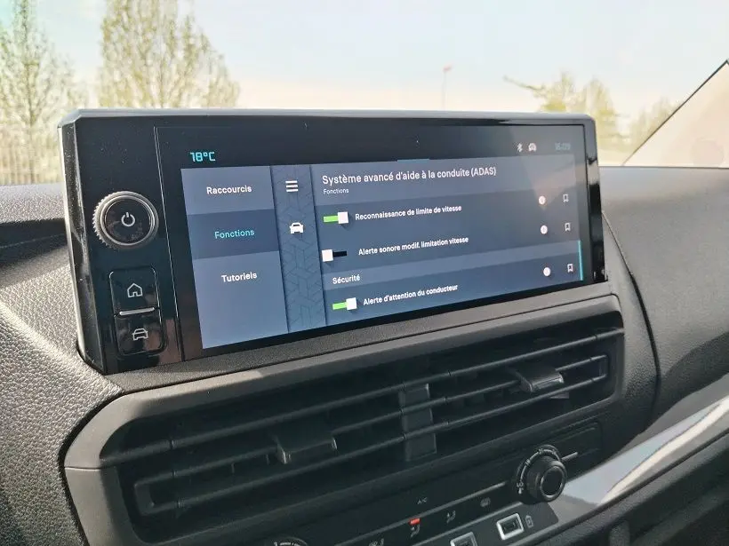 Vue rapprochée de l'écran tactile central du tableau de bord du Citroën Jumpy gris titane, affichant les aides à la conduite.