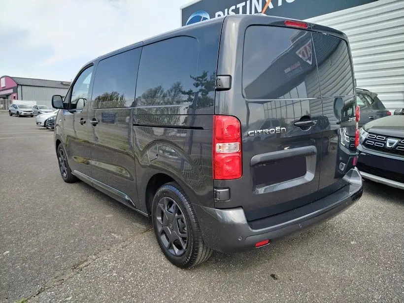 Vue 3/4 arrière droite d’un Citroën Jumpy Cabine Approfondie gris titane avec portes latérales coulissantes et roues tôlées noires.