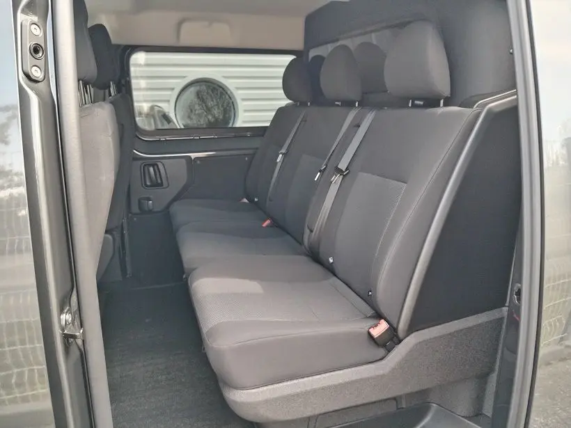 Vue intérieure côté droit des sièges arrière gris foncé du Citroën Jumpy Cabine Approfondie 2025 avec ceinture de sécurité.