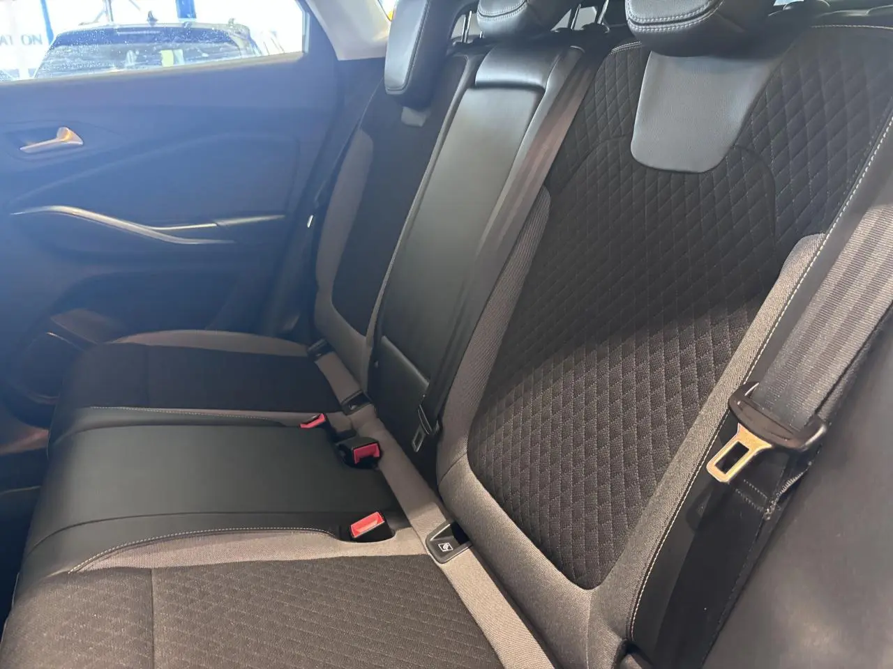 Vue latérale droite de la banquette arrière noire avec appuis-tête et ceintures de sécurité de l’Opel Grandland 2019.