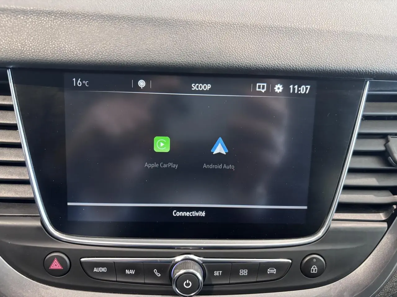 Écran tactile central de l’Opel Grandland rouge foncé, affichant Apple CarPlay et Android Auto.