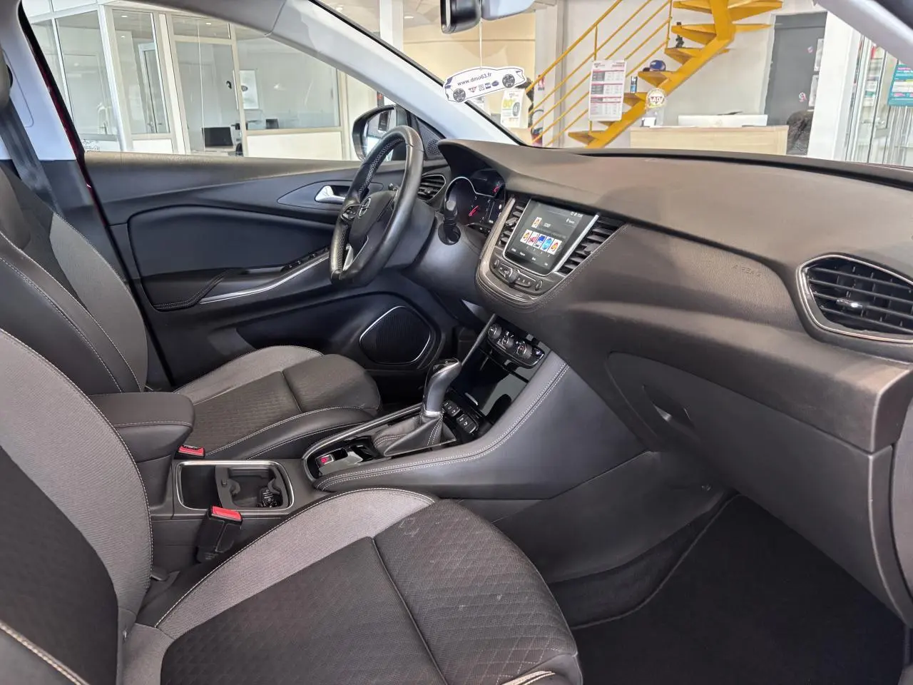 Intérieur Opel Grandland X 2019 vu côté conducteur, avec tableau de bord noir et console centrale équipée d'une boîte automatique.