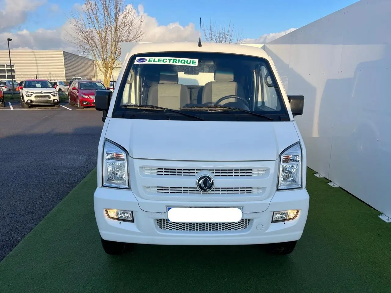 Vue frontale d'un fourgon blanc SERES DFSK EC35 électrique 2022 avec autocollant "ELECTRIQUE" sur le pare-brise.