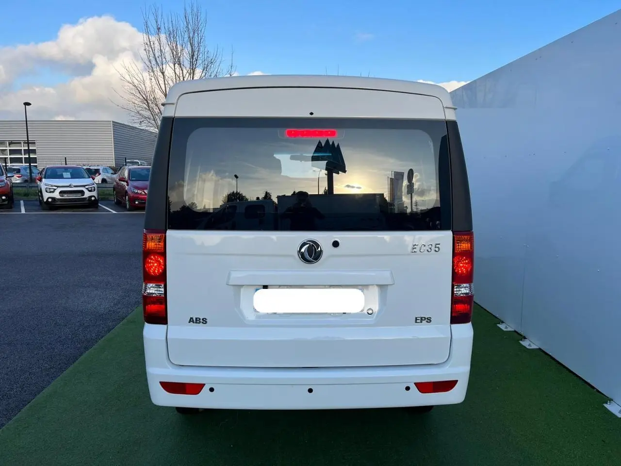 Vue arrière d'un fourgon blanc SERES DFSK EC35 électrique 2022 avec feux allumés et vitres teintées.