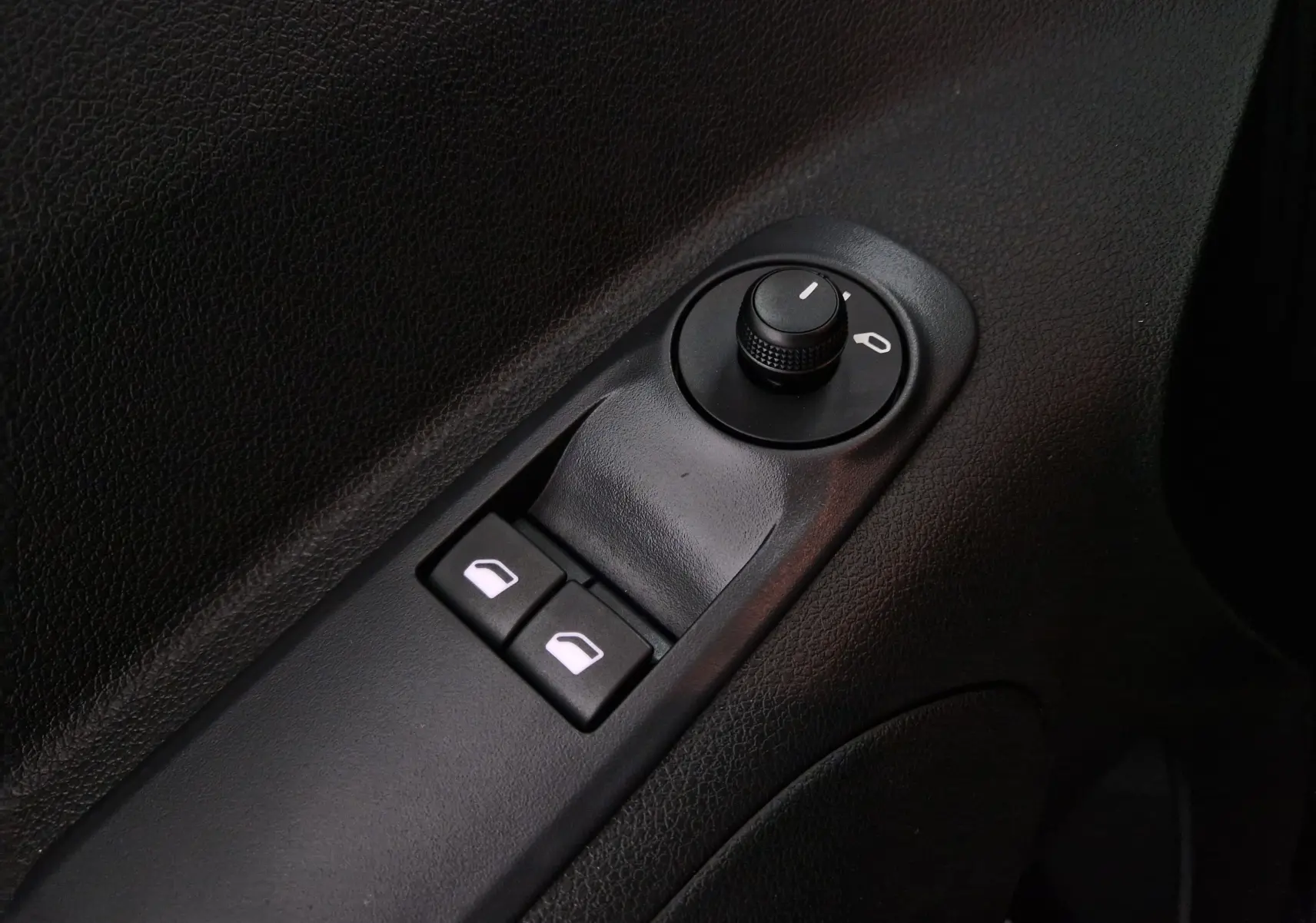 Gros plan sur les commandes de réglage des rétroviseurs et des vitres électriques côté conducteur de l'Opel Combo Life 2025.