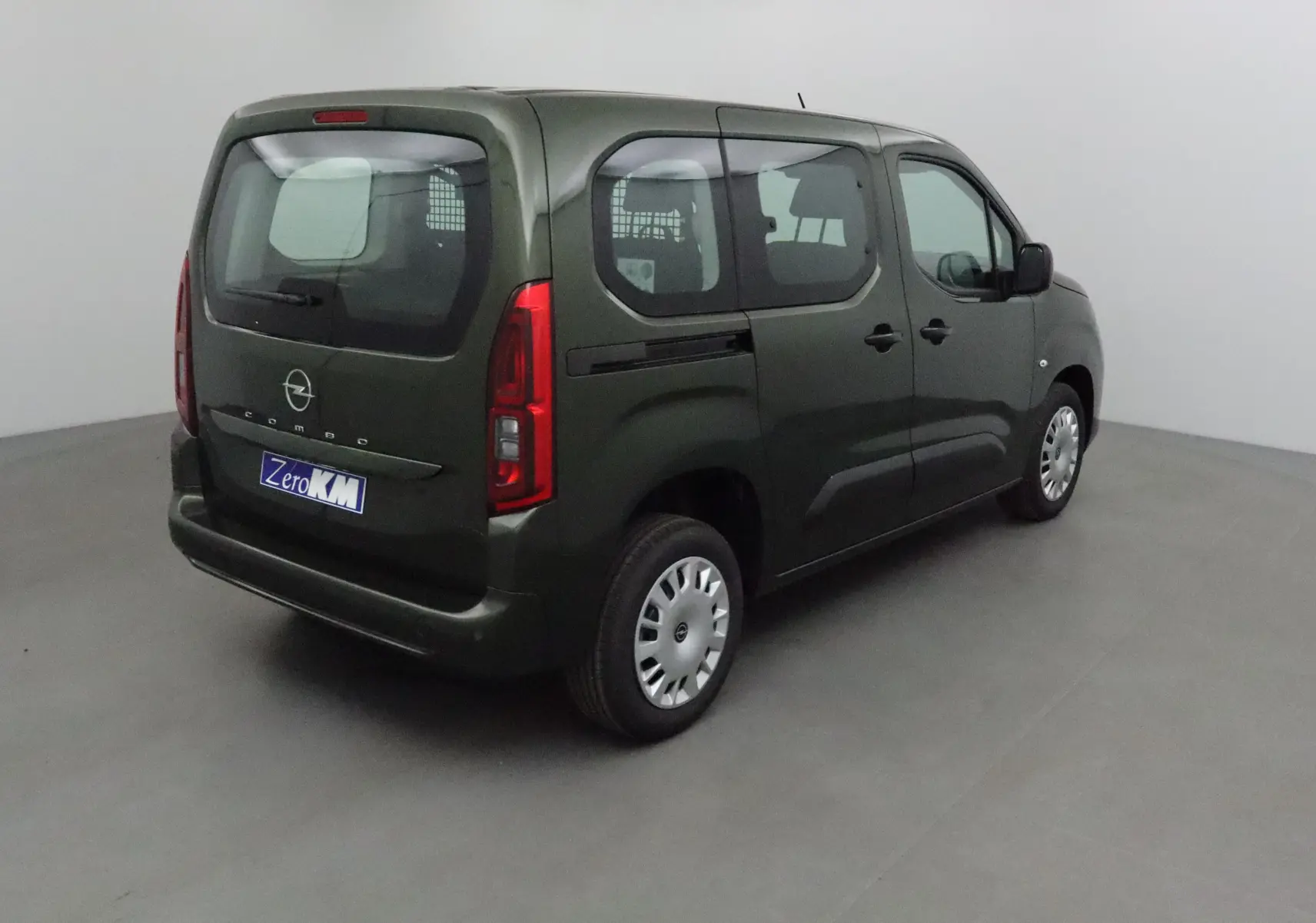 Vue 3/4 arrière droite d'un Opel Combo Life vert Sirkka avec grille de séparation visible à l'intérieur.