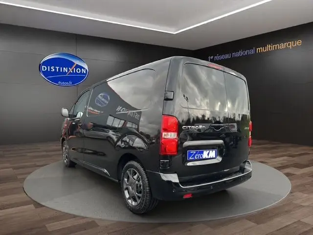 Vue 3/4 arrière droite d'un Citroën Jumpy noir 2025 avec jantes foncées et vitres teintées en showroom.