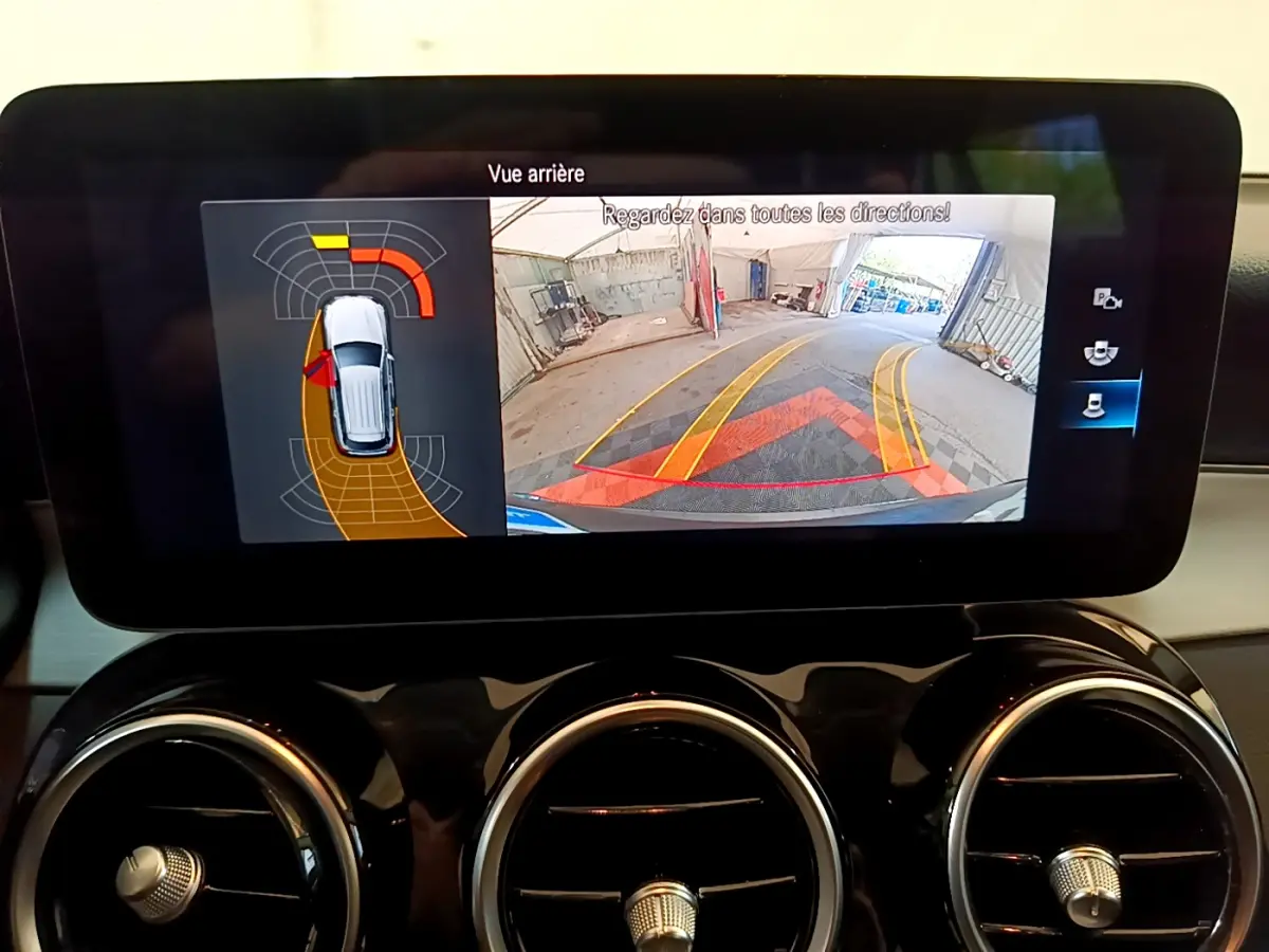 Écran tactile intérieur du Mercedes GLC 300 E AMG Line 2021 affichant la caméra de recul et l'aide au stationnement.