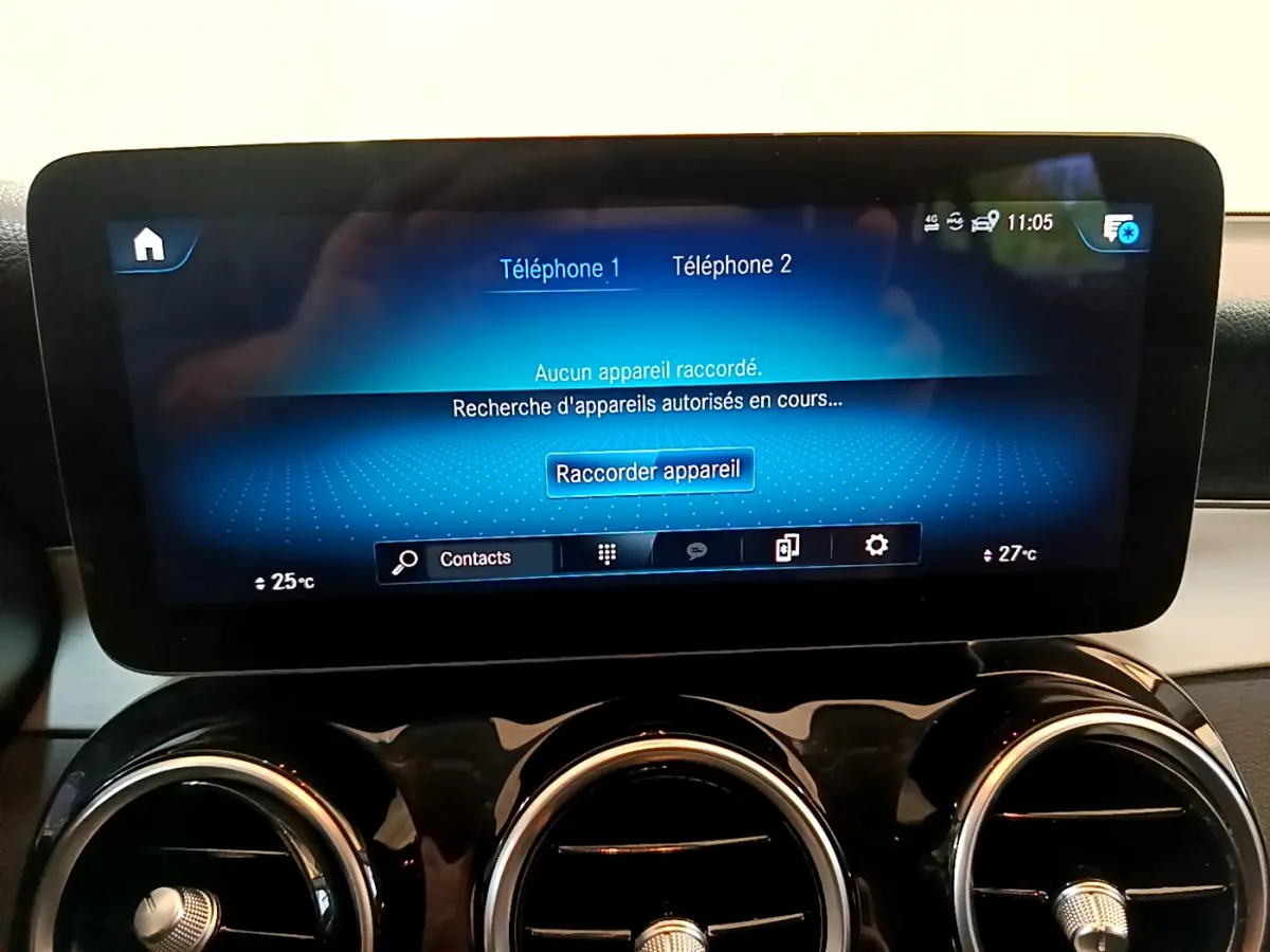 Écran tactile central affichant la connexion Bluetooth, avec aérateurs ronds chromés en dessous dans un Mercedes GLC 300 E AMG Line.