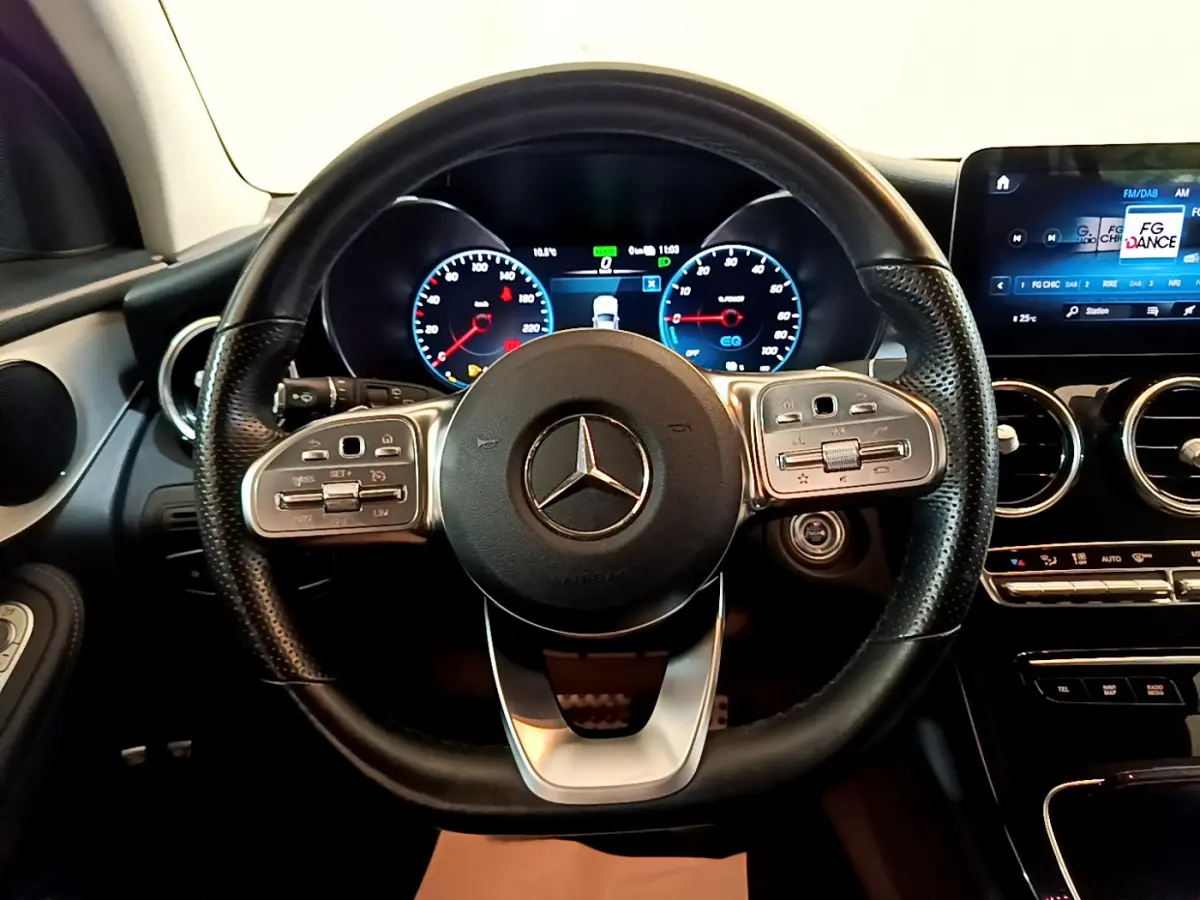 Vue centrée sur le volant cuir et alu de la Mercedes GLC 300 E AMG Line 2021 avec tableau de bord numérique et écran tactile.