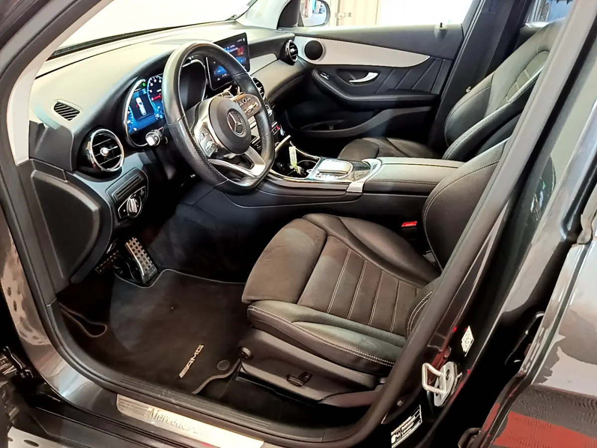 Intérieur côté conducteur du Mercedes GLC 300 E AMG Line 2021, sièges cuir noirs et tableau de bord digital.