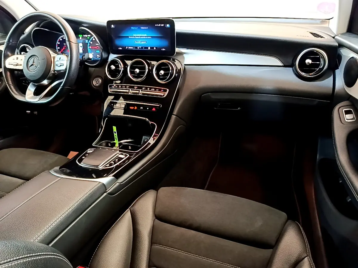 Intérieur du Mercedes GLC 300 E AMG Line 2021, vue côté conducteur sur tableau de bord et console centrale noire élégante.
