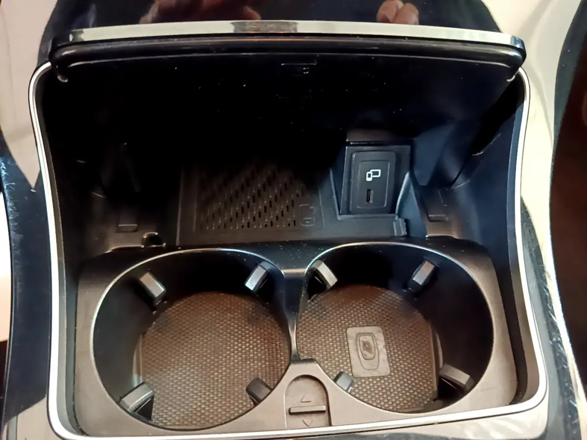 Gros plan sur les porte-gobelets et prise USB dans la console centrale du Mercedes GLC 300 E AMG Line gris foncé.
