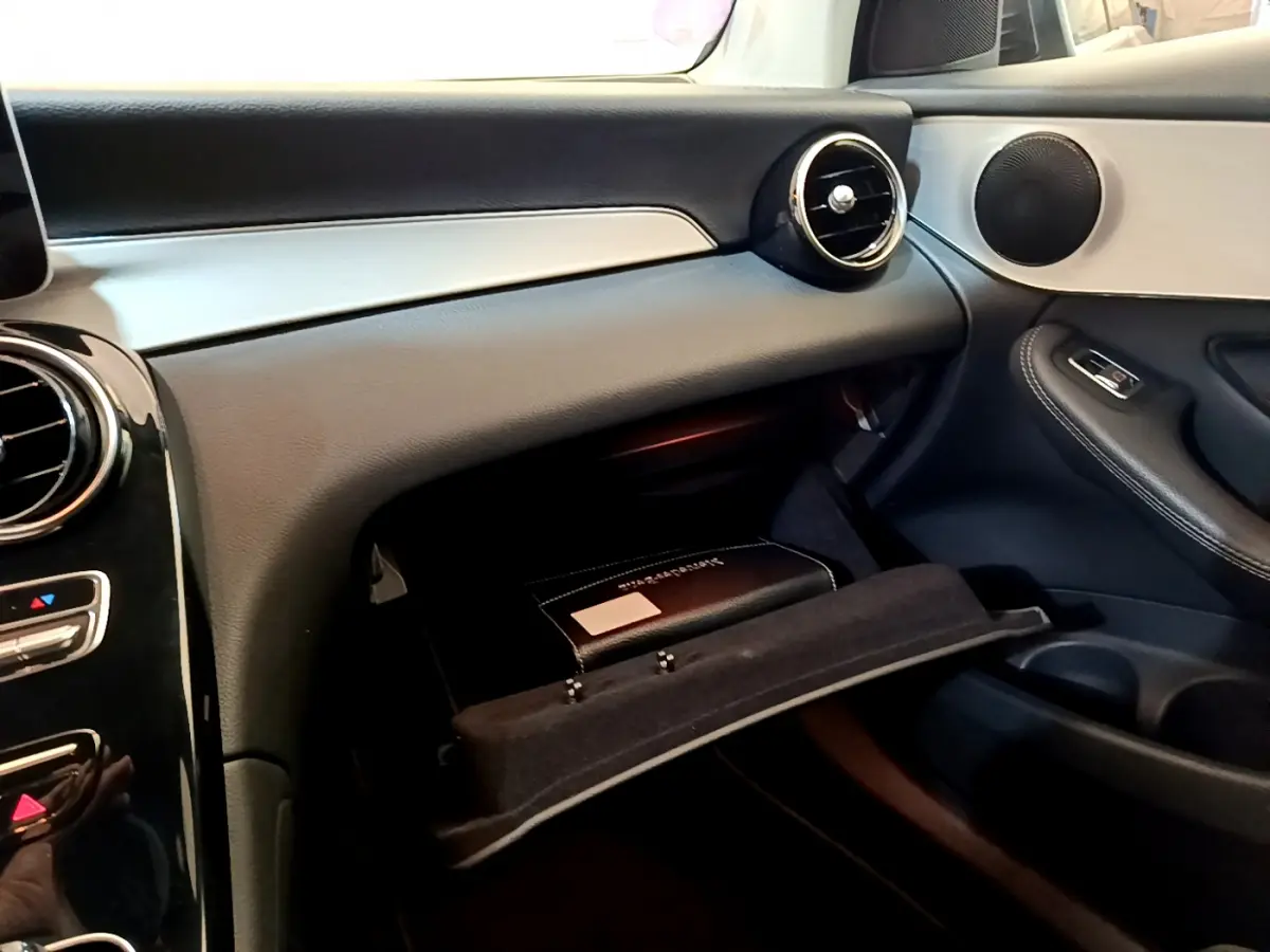 Intérieur Mercedes GLC 300 E AMG Line 2021, vue côté passager sur boîte à gants ouverte et tableau de bord noir et argenté.