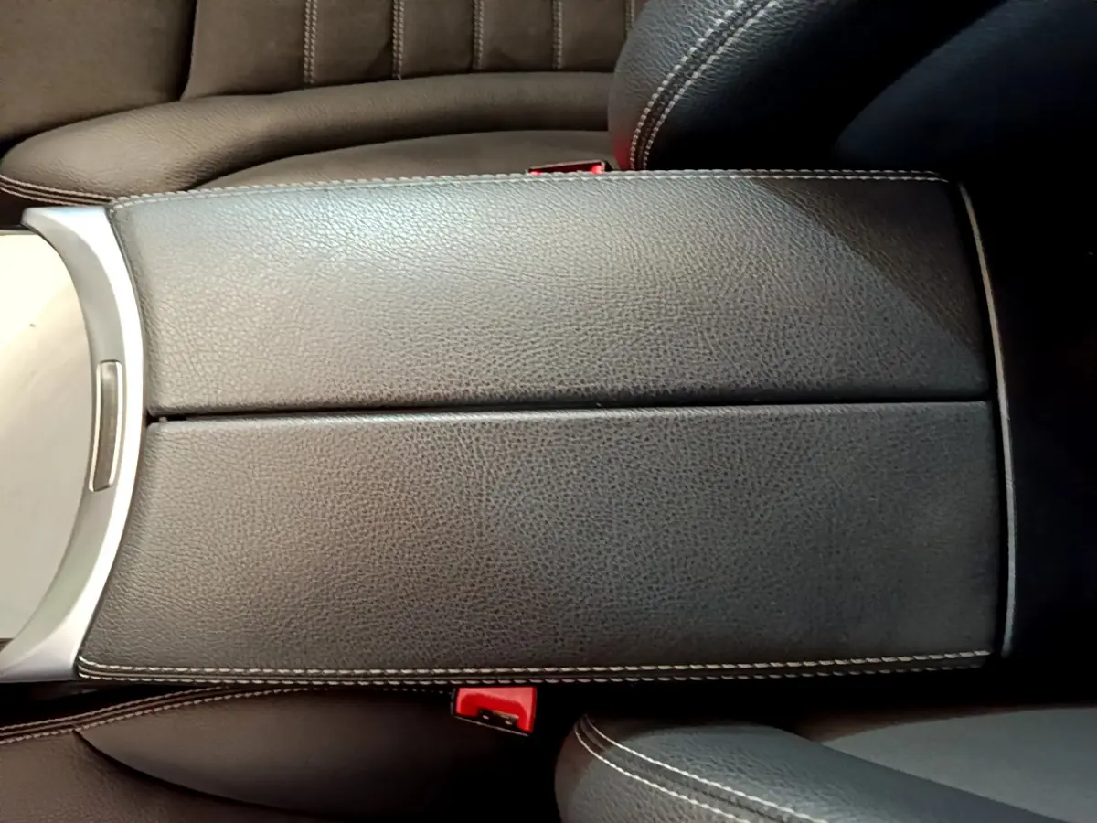 Accoudoir central en cuir noir avec surpiqûres blanches dans l'habitacle du Mercedes GLC 300 E AMG Line 2021.